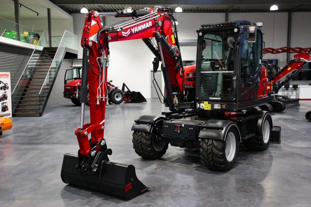 Compact landbouwschaarmachine met Yanmar-motor en robuuste banden op showroom.