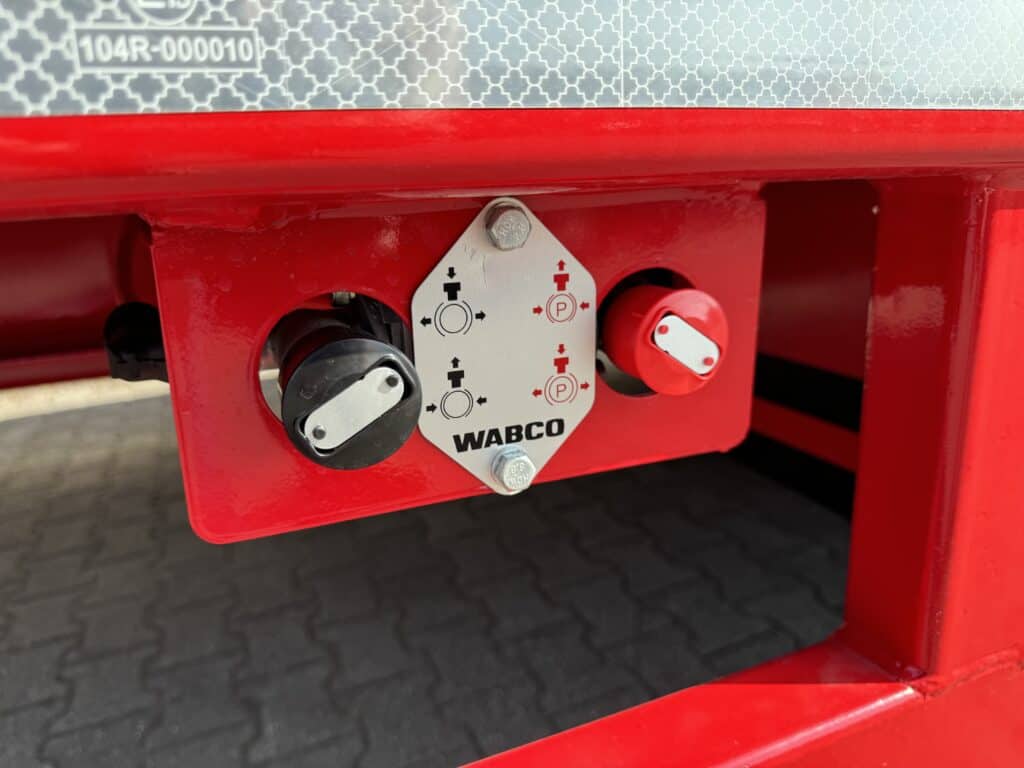 Robuuste koppeling voor landbouwmachines, WABCO systeem met hendels en indicatoren.