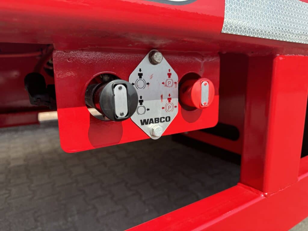 Stuurcentrum water- en drukregelaars op industrieel hydraulisch systeem in rood.