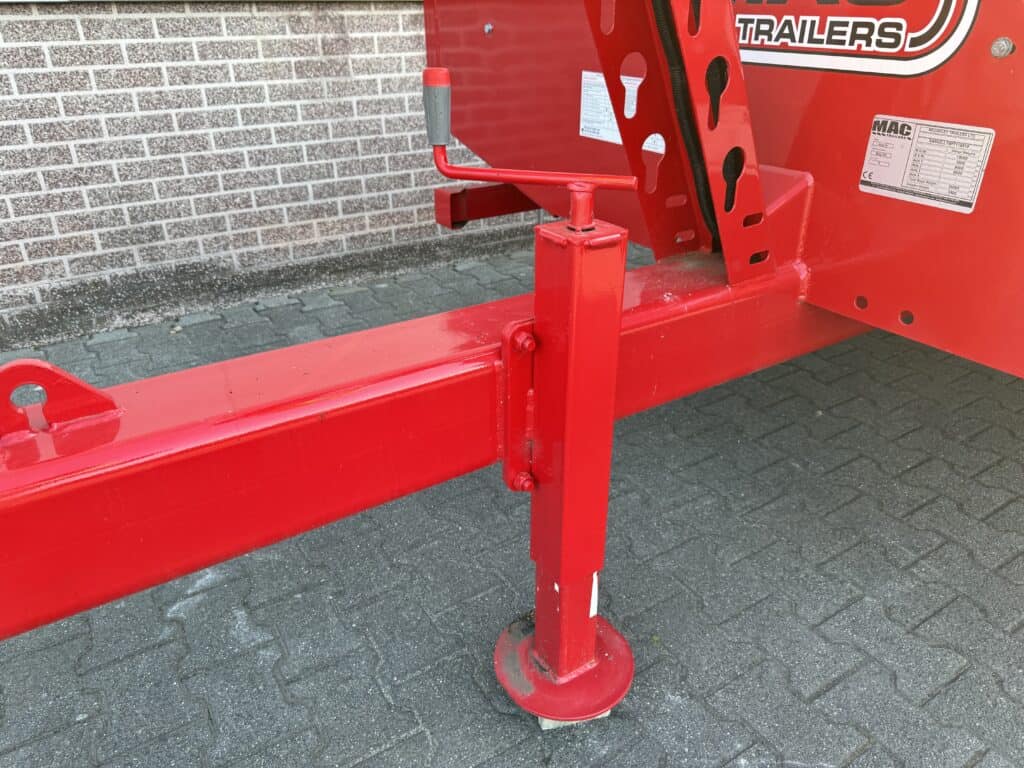 Voorkant van rode trailer met stabilisatievoet en hijsogen, geschikt voor transport en opslag.