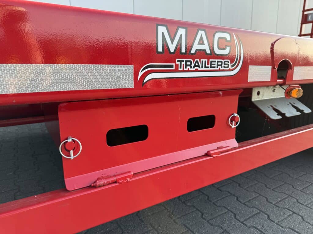 Hoge resolutie rode trailer met MAC Trailers logo, geschikt voor zwaar transport en logistiek.