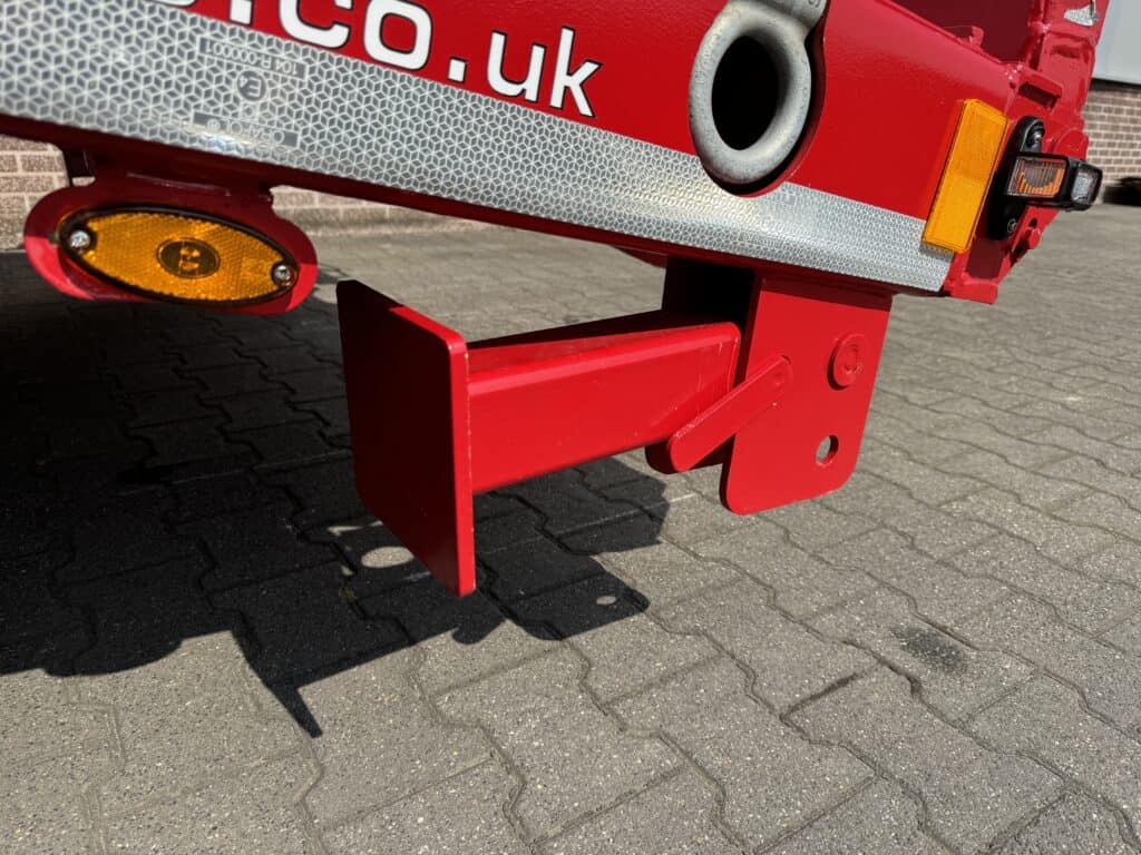 Veiligheidstrailer met reflectoren en beveiligingsbeugel op verhard wegdek.