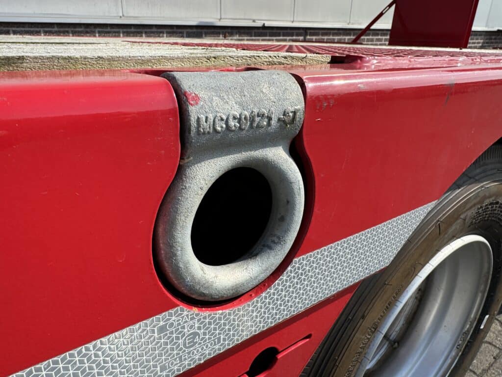 Ultrasoon sensor op rood machineonderdeel met technische details.