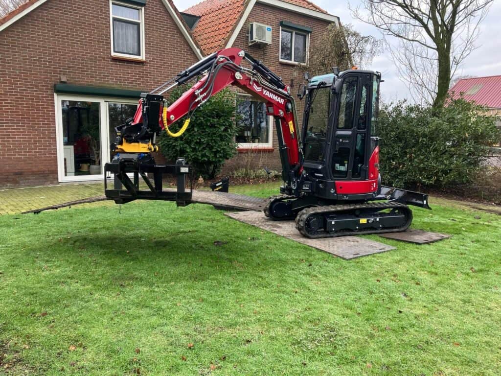 Klein graafmachine op bouwplaats voor tuinwerk en grondverzet.