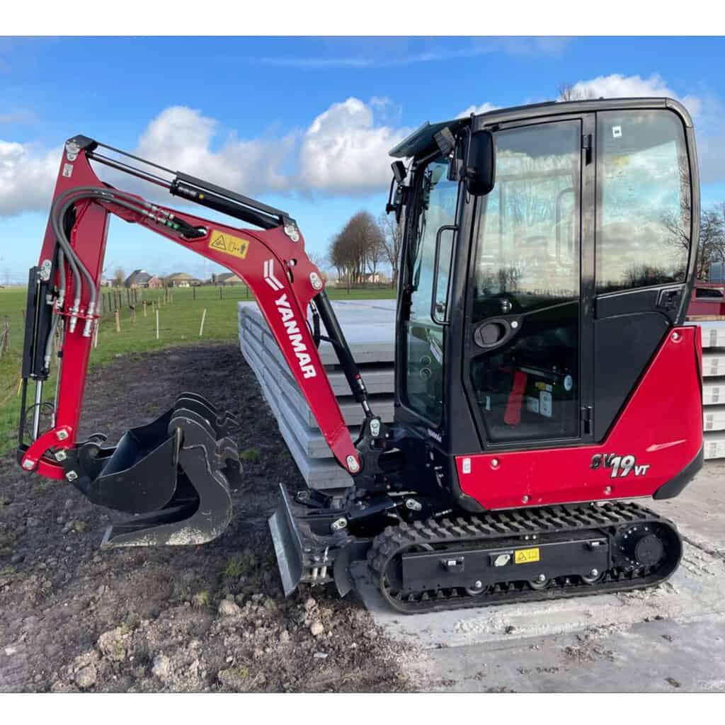 Klein-minibagger op bouwplek met panoramadak en rubberen rupsbanden, geschikt voor tuinwerkzaamheden.
