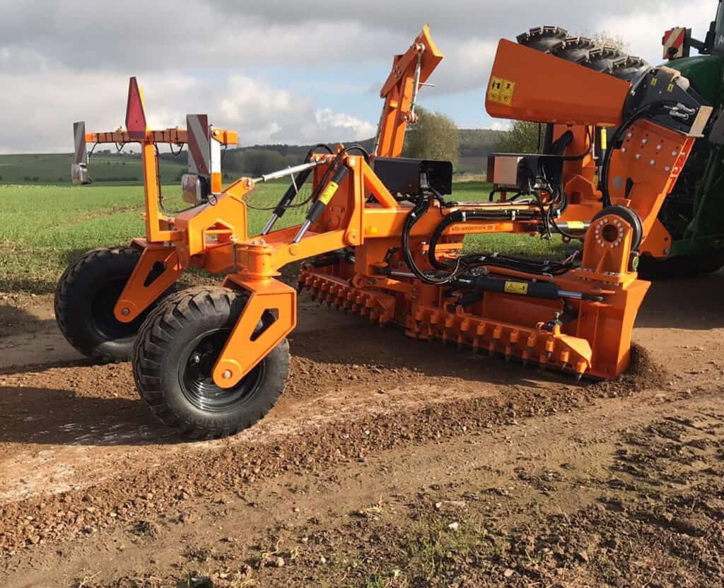 Robuuste landbouwmachine in oranje voor bodembewerking op een akker, ideaal voor professionele boeren.