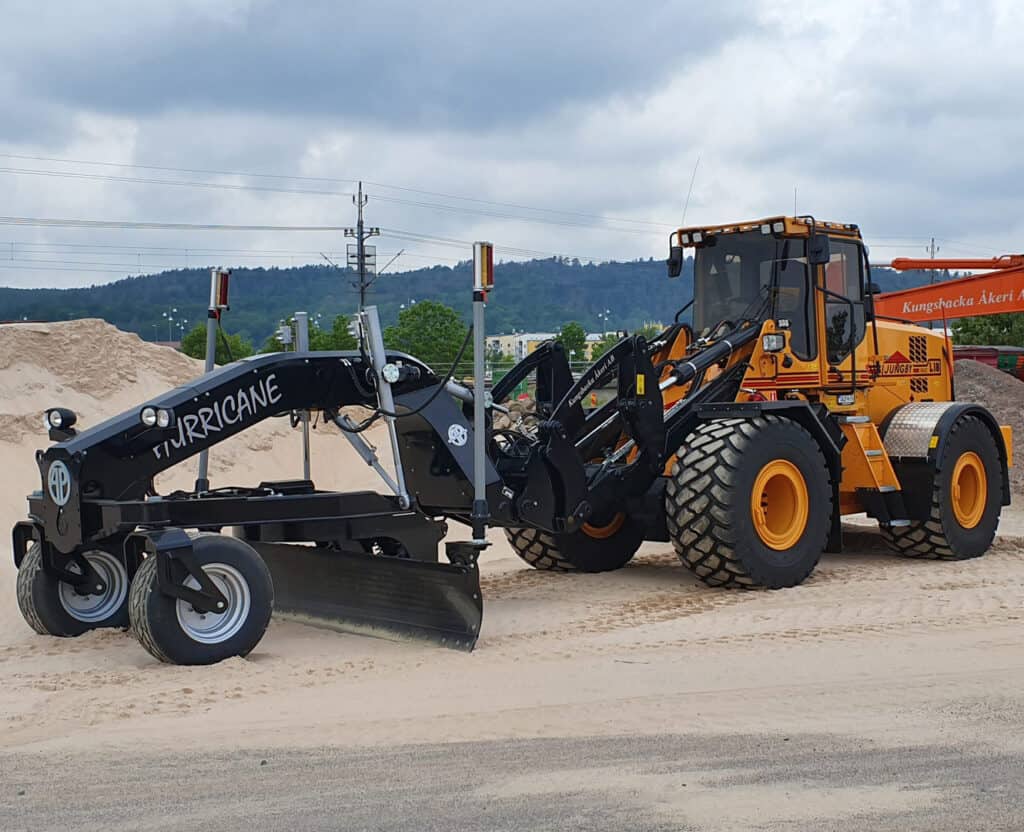 1. Zware bouwmachine met weil aanhangwagen voor grondbewerking op bouwplaats.