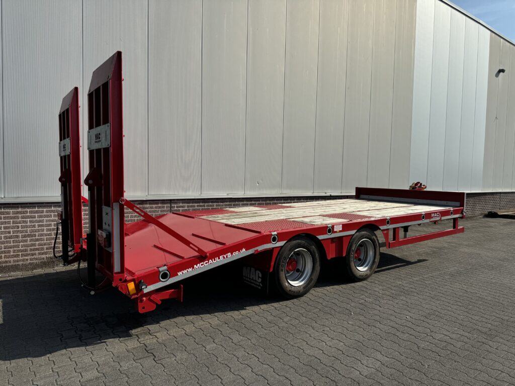 Veetransportwagen voor het vervoer van voertuigen, zwart met rode accenten, op een zwarte ondergrond.