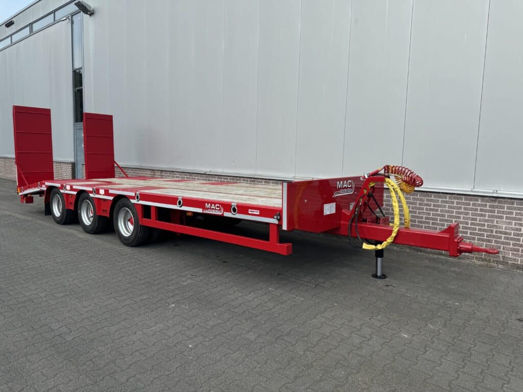 Slecht zichtbare laadwagen voor zwaar transport met uitschuifbare ladingrand, geel en rood gekleurd.