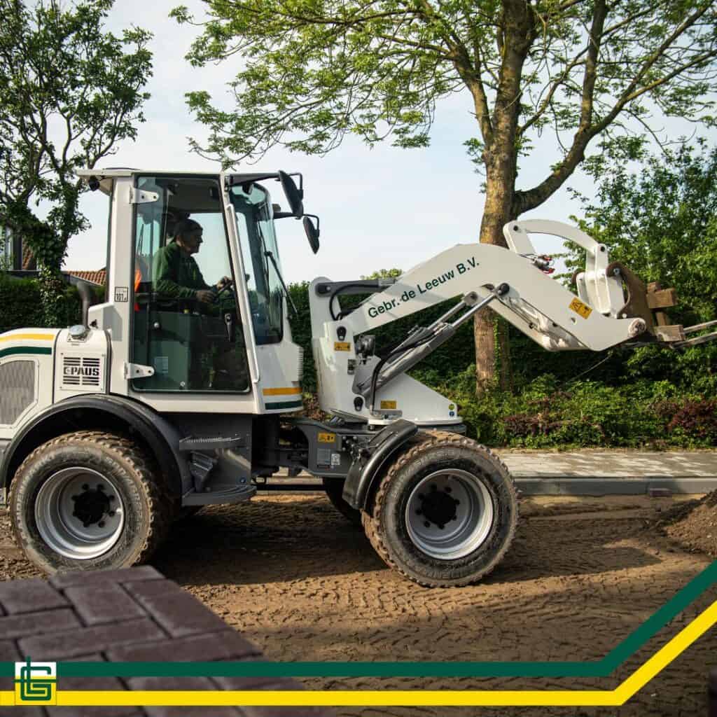 Robuuste graafmachine op bouwplaats voor tuin- of wegenbouw, met bedrijfsaanduiding.