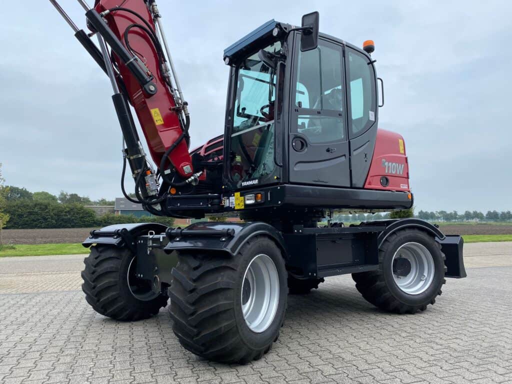 Compacte wiellader op verharde ondergrond, geschikt voor bouw- en landbouwwerkzaamheden.