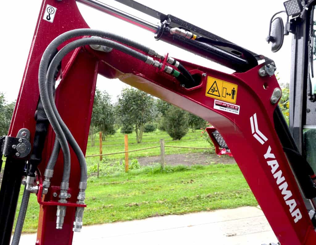 Hydraulische bediening van Yanmar graafmachine met veiligheidswaarschuwing.
