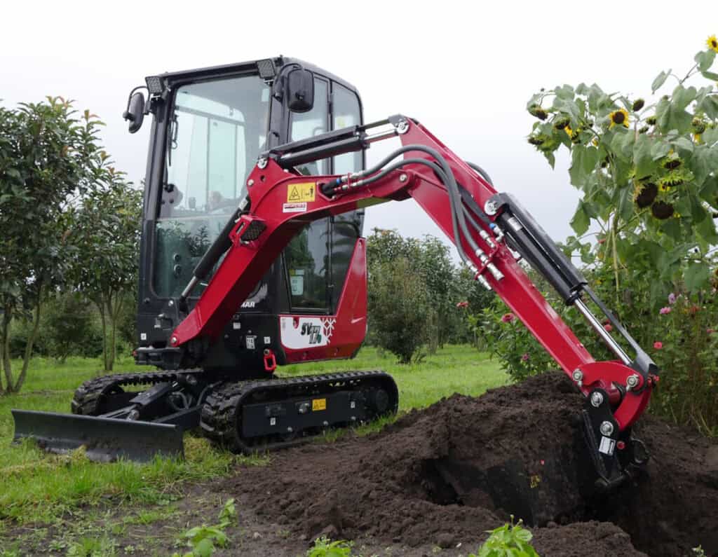 Klein graafmachine met rubberen rupsen en cabine voor tuin- en landschapsonderhoud.