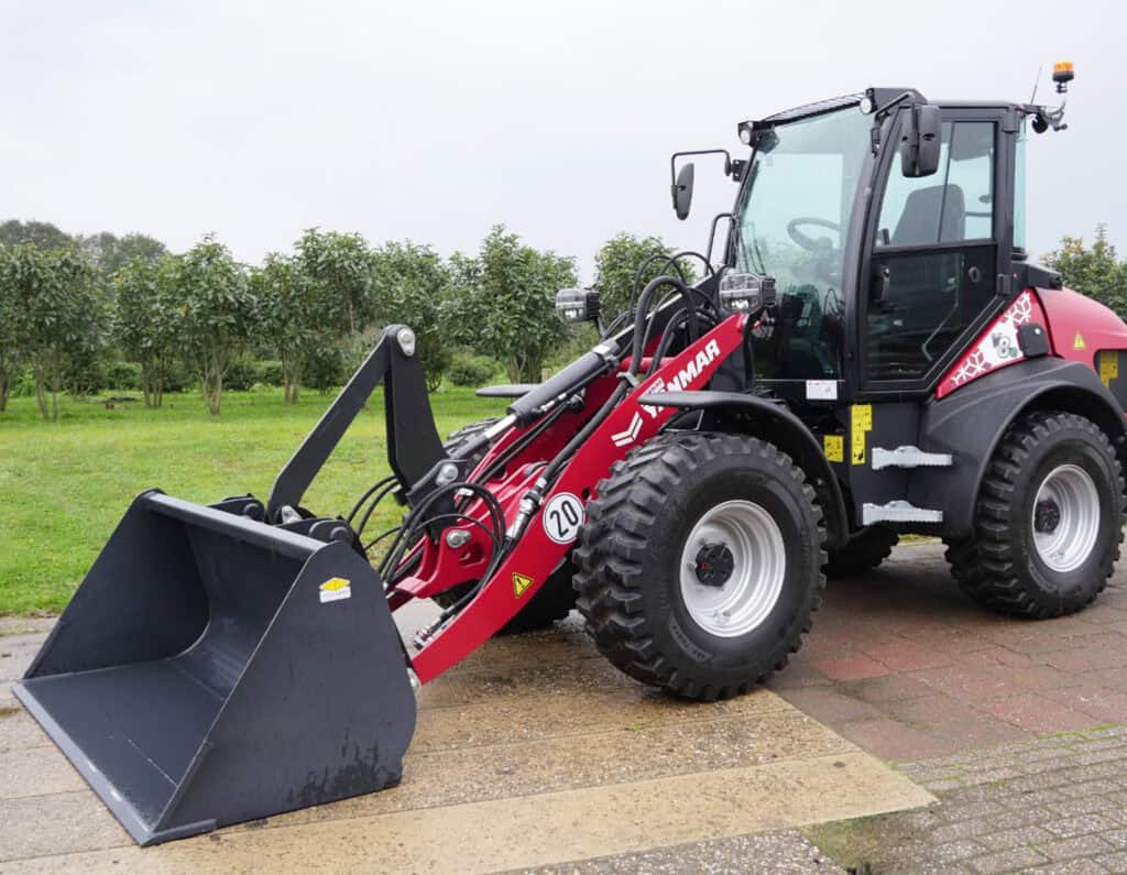 Advanced landbouwmachine met laadbak en hijsarm, geschikt voor agrarisch gebruik.
