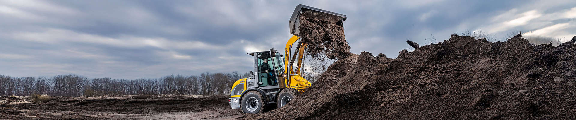 Mobiele graafmachine bij grondwerkzaamheden op bouwplaats, gespecialiseerd in executie, aanneming en grondverzet.