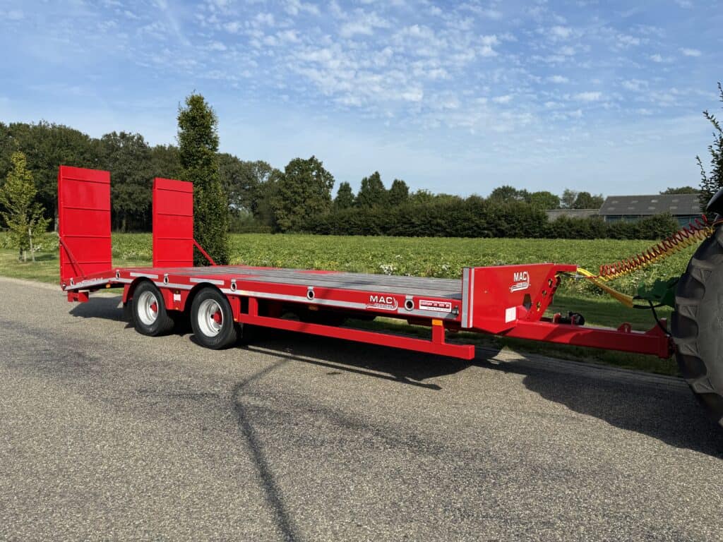 Robuuste rode landbouwtrailer voor tractoren, ideaal voor het vervoeren van landbouwmachines en oogstproducten.
