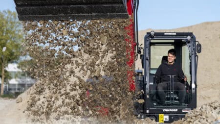 Stilte, jonge man bestuurt minishovel voor grondverzet en bouwwerkzaamheden.