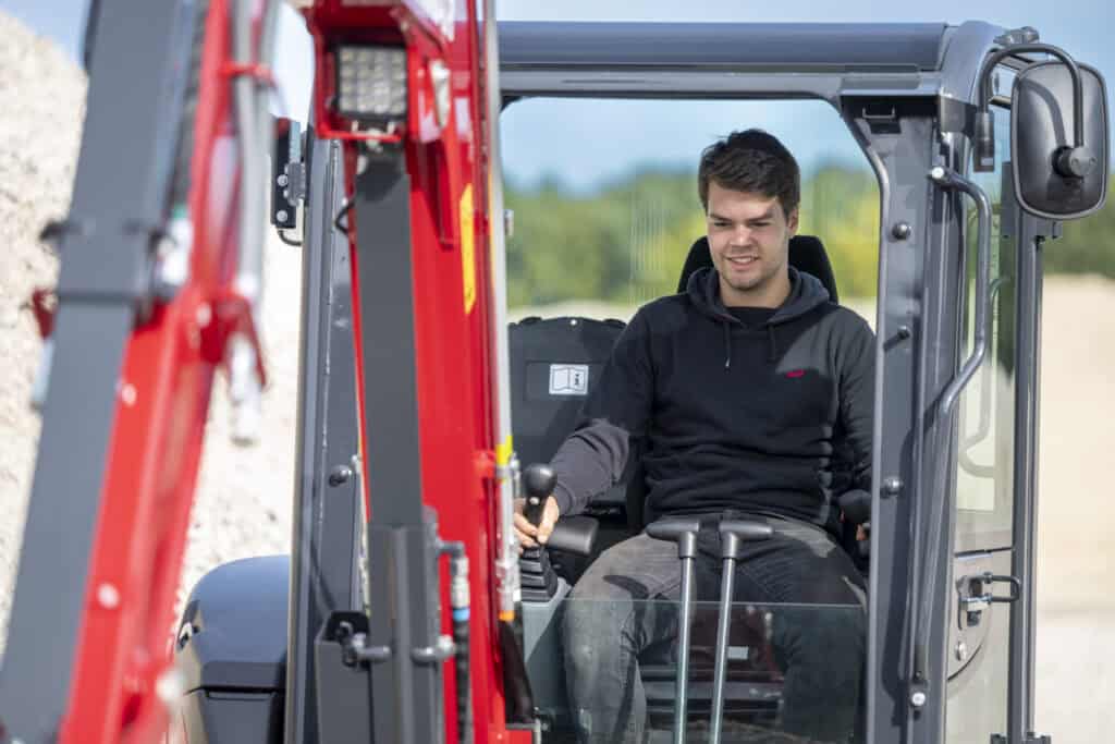 Veilig werken met compactieve graafmachine en professionele machinist op bouwlocatie.