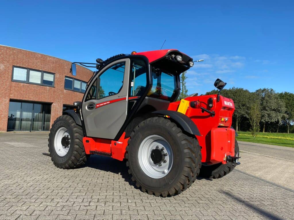 Robuuste Manitou telehandler met ruime cabine en grote banden, geschikt voor bouw en tuinieren.