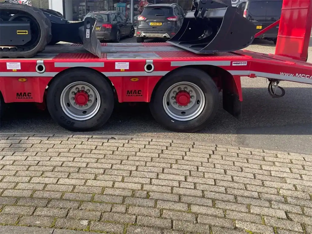 Veetransportwagen met bouwmachines voor aannemerij en wegenbouw.