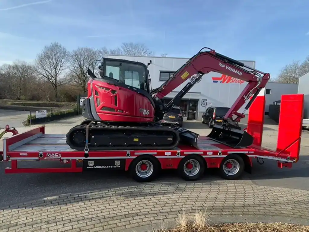 Mini graafmachine op transportwagen voor bouw- en tuinprojecten.
