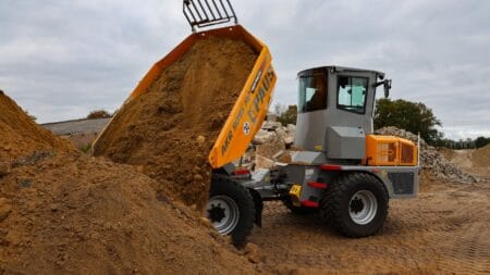 Klepelkuiler in actie bij bouwproject, gespecialiseerd in grondverzet en grondwerkzaamheden.