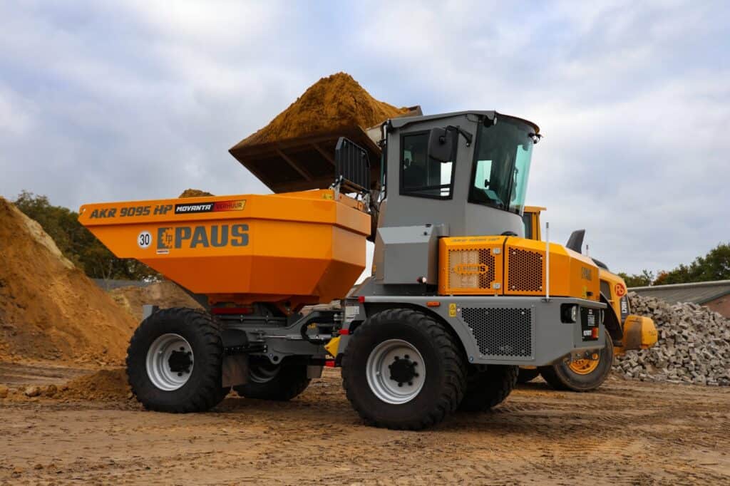 Kleuren geel en grijs, bouwvoertuig met speciekuip op bouwplaats, bouwmachines, bouwwerkzaamheden, bouwbedrijf.