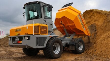 Hoogwaardige graafmachine van PAUS op bouwplaats, met graafbak en zandheuvels, professioneel bouwmaterieel.