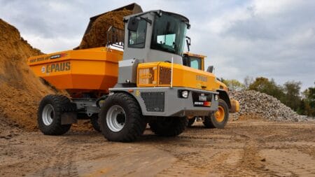 Robuuste betonnen wiellader op een bouwplaats met aarde en gesteente.