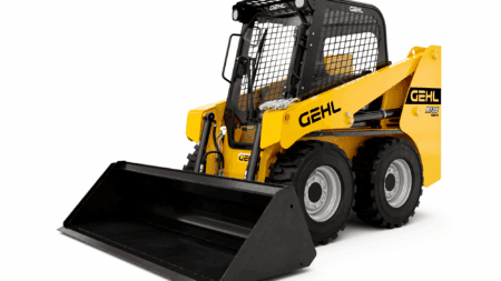 Kleiner wielzwenkbare wiellader met cabine en oprijplaat, geschikt voor bouw en tuinwerk.