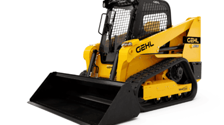 Klein geleide rupskraan met cabine en rubberen tracks, ideaal voor bouwtransport.