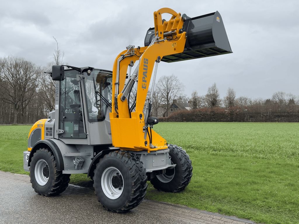 Luchtige graafmachine van Paus met cabine op grasveld, ideaal voor bouw en tuinwerkzaamheden.