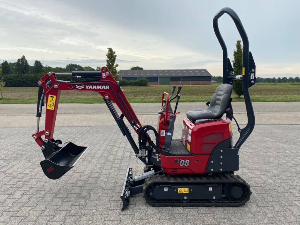 Mini minikraan op wegdek, geschikt voor grondbewerking en tuinprojecten.