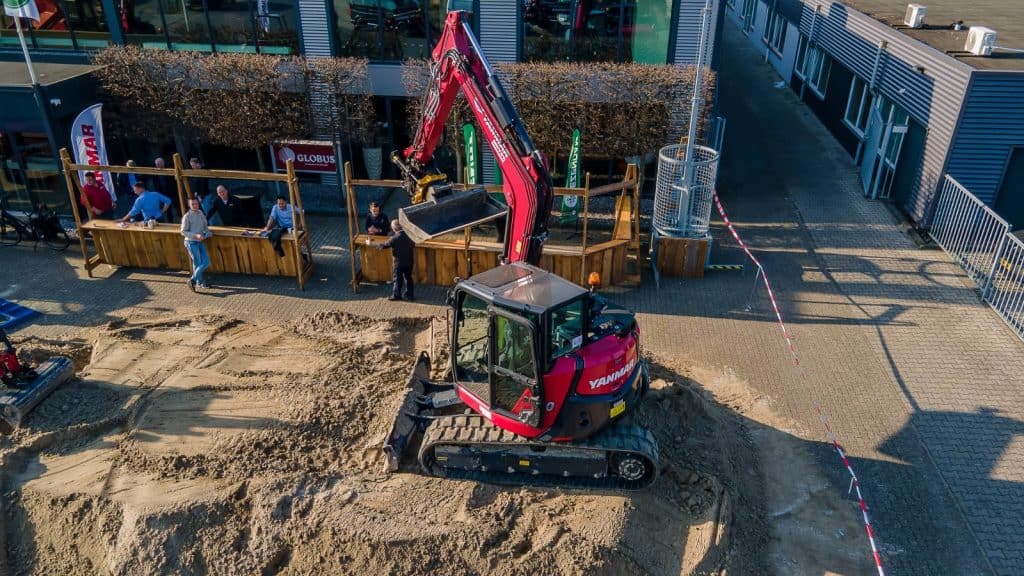 1. Graafmachine in actie bij bouwproject met bouwplaats en vaklui.