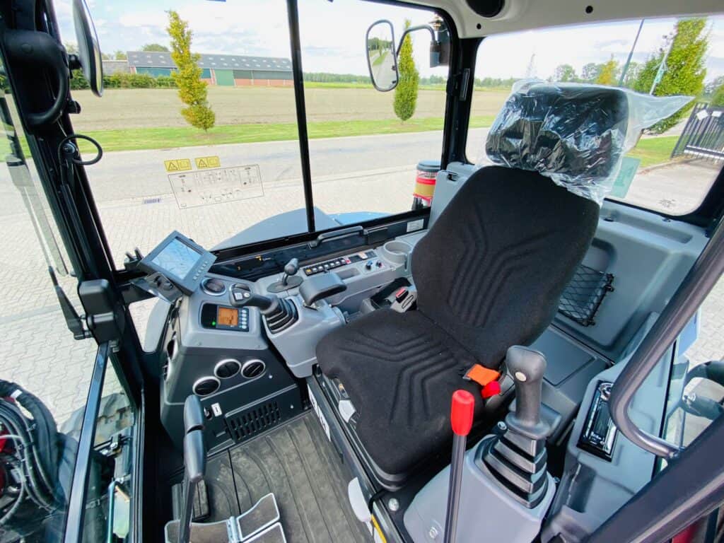Veilig bestuurbare landbouwmachine cabine met geavanceerd bedieningspaneel en comfortabele stoel.