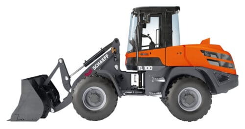 Front-end loader (Schaeff TL 100) with an orange cab and black bucket attachment ready to scoop material outside the frame far left-side view
