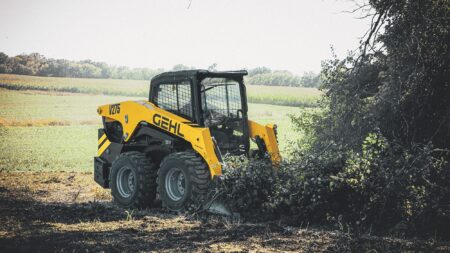 Hoge kwaliteit mini skid steer loader van GEHL in een landelijke groen omgeving.