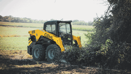 Hoge kwaliteit mini skid steer loader van GEHL in een landelijke groen omgeving.
