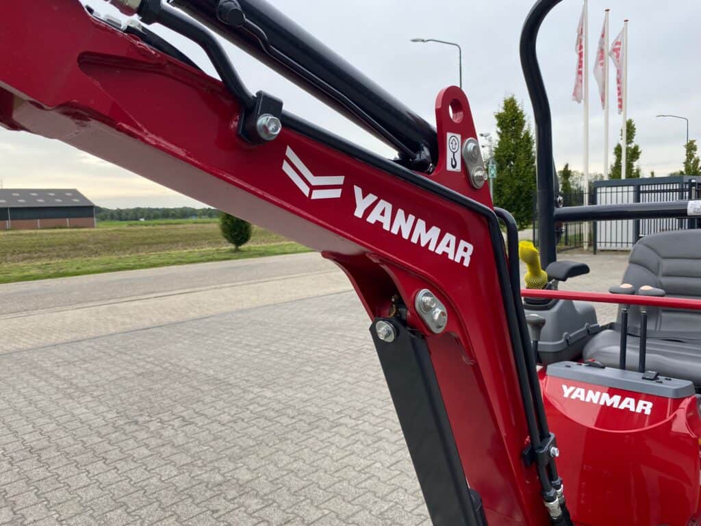 1. Uitgebreide foto van een Yanmar mini tractor met hijsarm op een bedrijfsterrein.