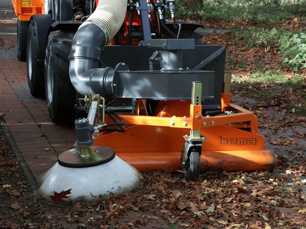 Trekker met bladblazer voor tuinonderhoud op verhard pad.