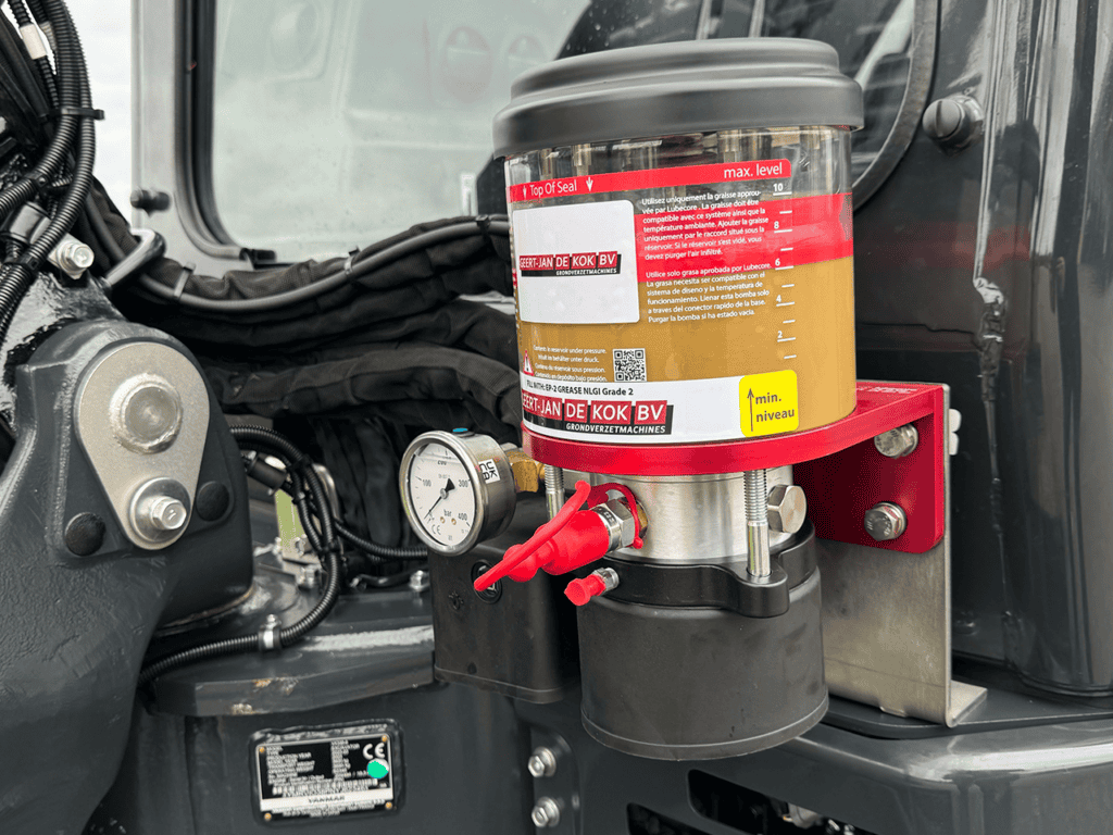 1. Alternatief tekst: Graasolie container voor smeer- en onderhoudsdoeleinden op grindmachines.