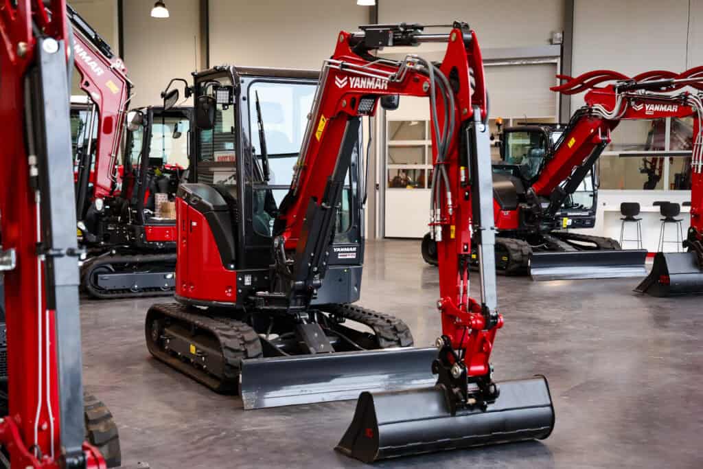 Kleine Yanmar graafmachine in showroom, nieuwe compacte bouwmachine, met rubberen rupsbanden.