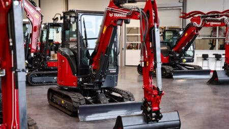 Kleine Yanmar graafmachine in showroom, nieuwe compacte bouwmachine, met rubberen rupsbanden.