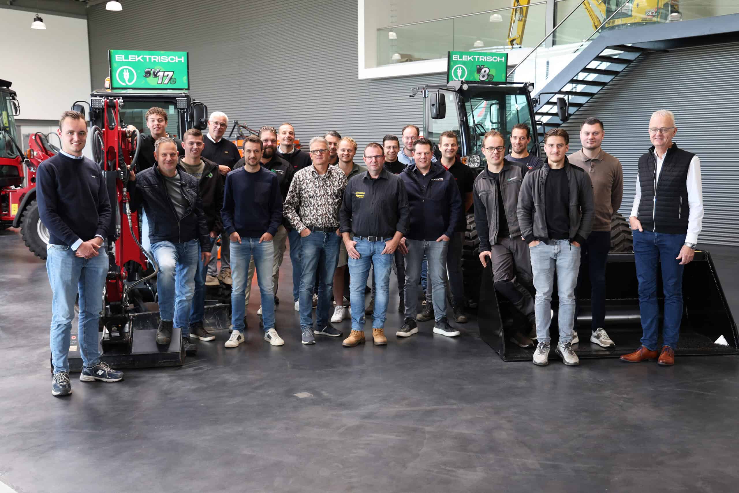 1. Groepsfoto van het team van Geert-Jan de Kok B.V. met landbouwmachines in de werkplaats.