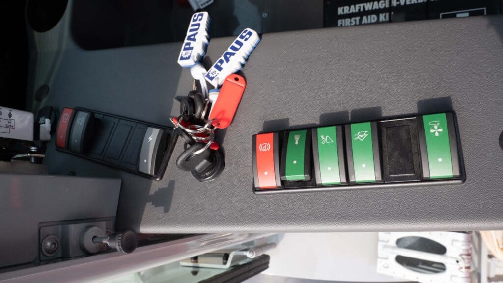 Veiligheidsbediening op een vrachtwagen dashboard met verschillende controleknoppen en toebehoren.