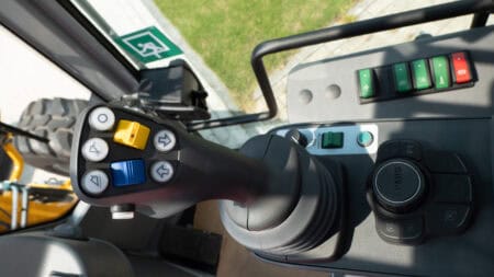 Een tractorstuur met controleknoppen en displays voor agrarisch gebruik.