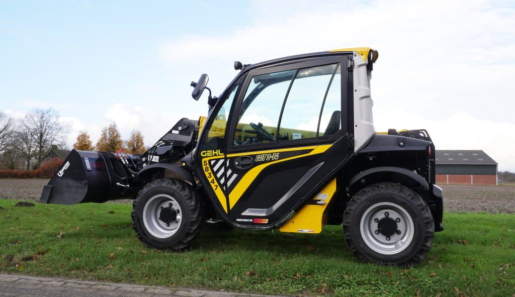 1. Compacte telehandler voor landbouw en bouw op grasveld.