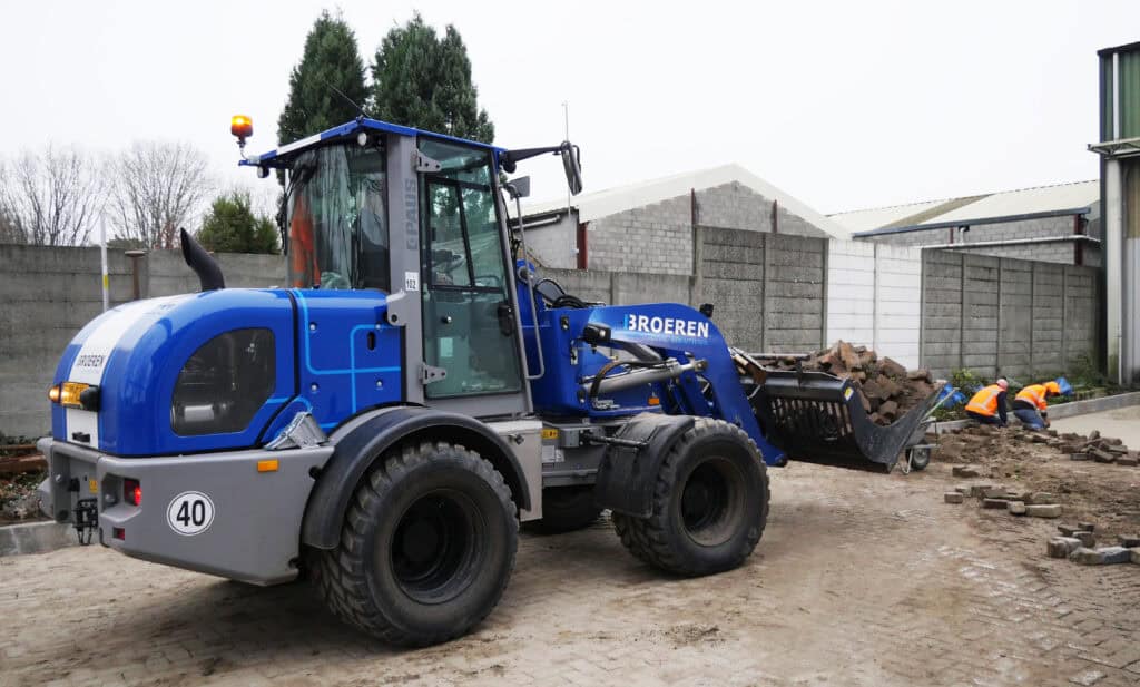 Kleine afbeelding van een bouwmachine op een bouwplaats met twee arbeiders, focusing op wegenbouw en civiele oplossingen.
