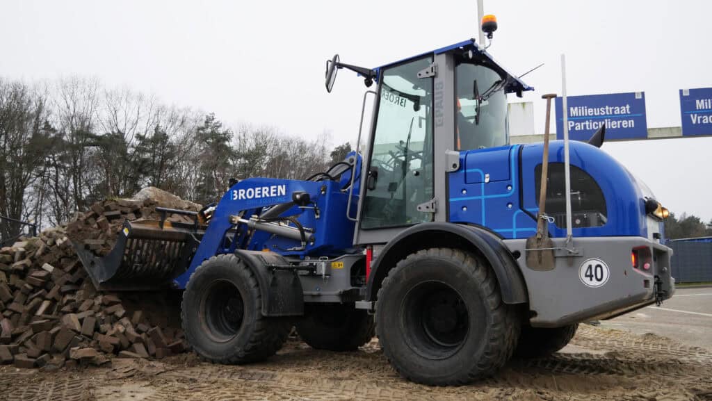 Stadsgrondwerker met graafmachine voor infrastructuur en bouwprojecten.