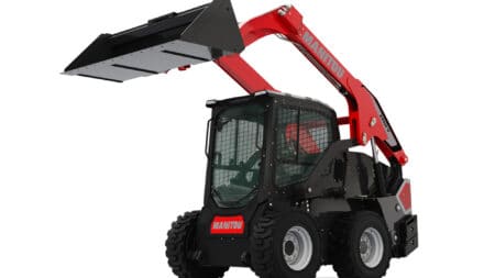 Robuuste skidoad met hefarm en cabine, geschikt voor bouw en agrarisch gebruik.